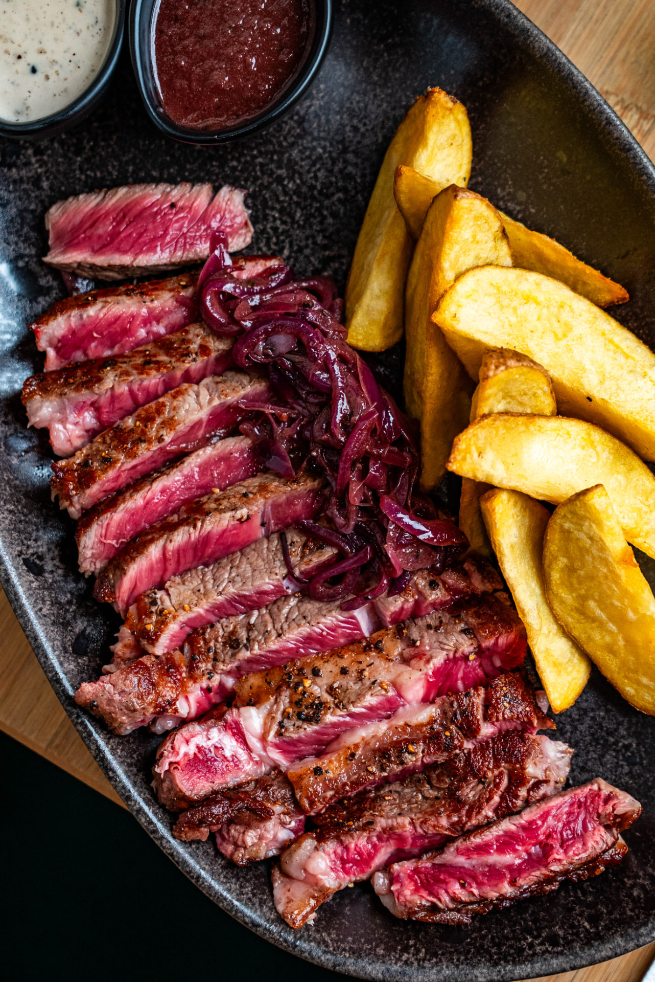 Tagliata de bœuf, oignons rouges confits et pommes de terre au four