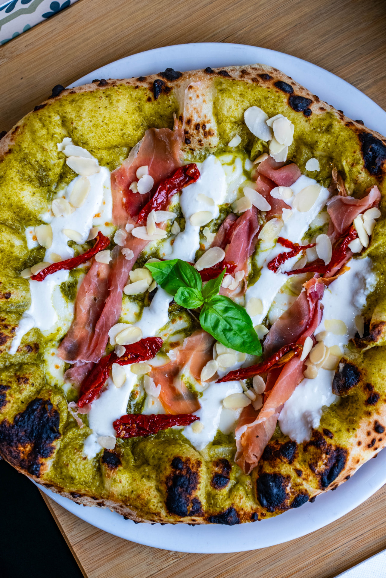 Pizza au pesto, burrata, jambon cru et tomates séchées